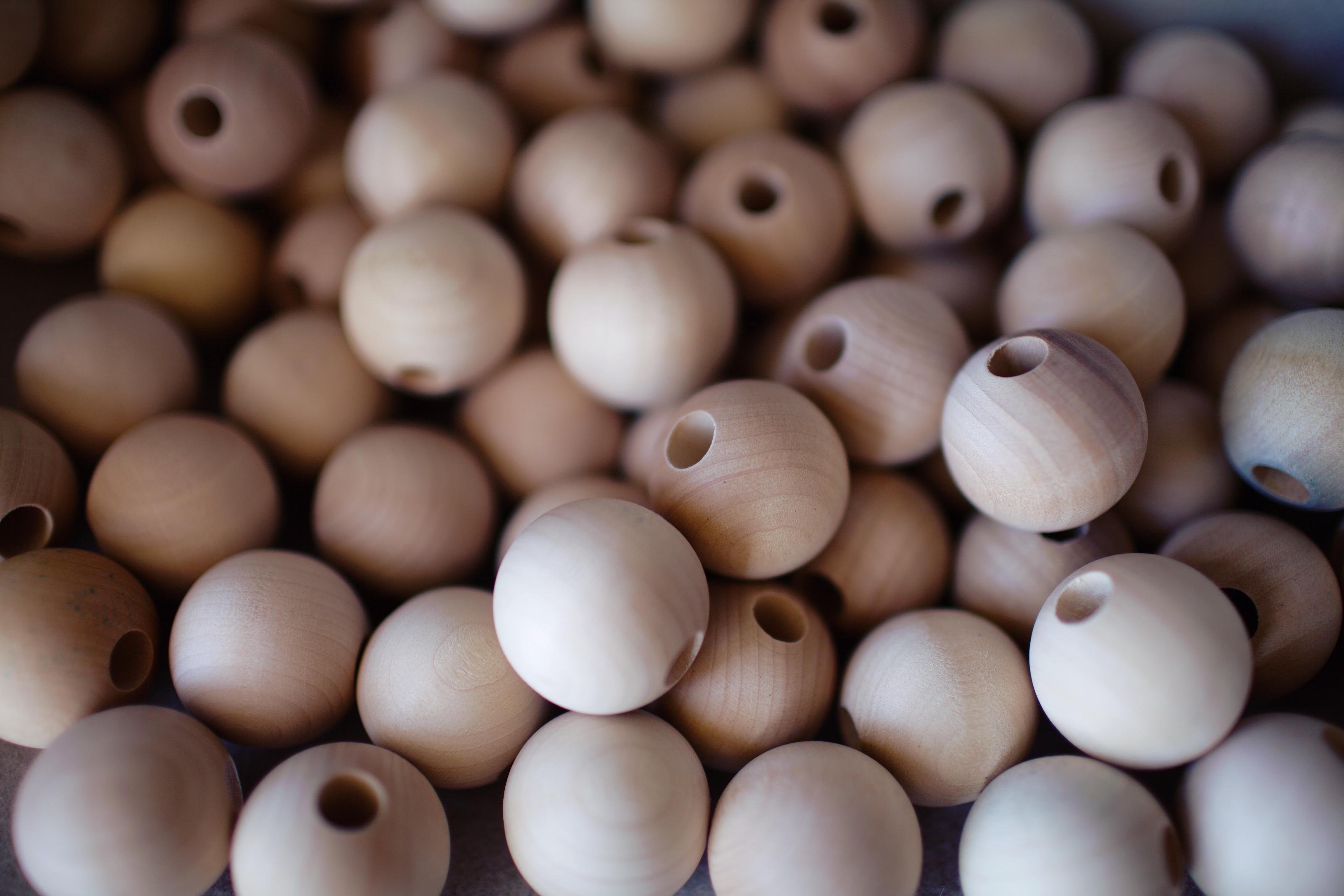 Unpainted wooden beads, each drilled through the center